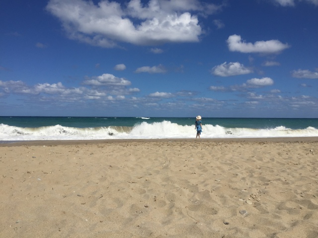 Woman walking along a beach with crashing waves