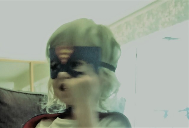 Child wearing a super hero cape and mask